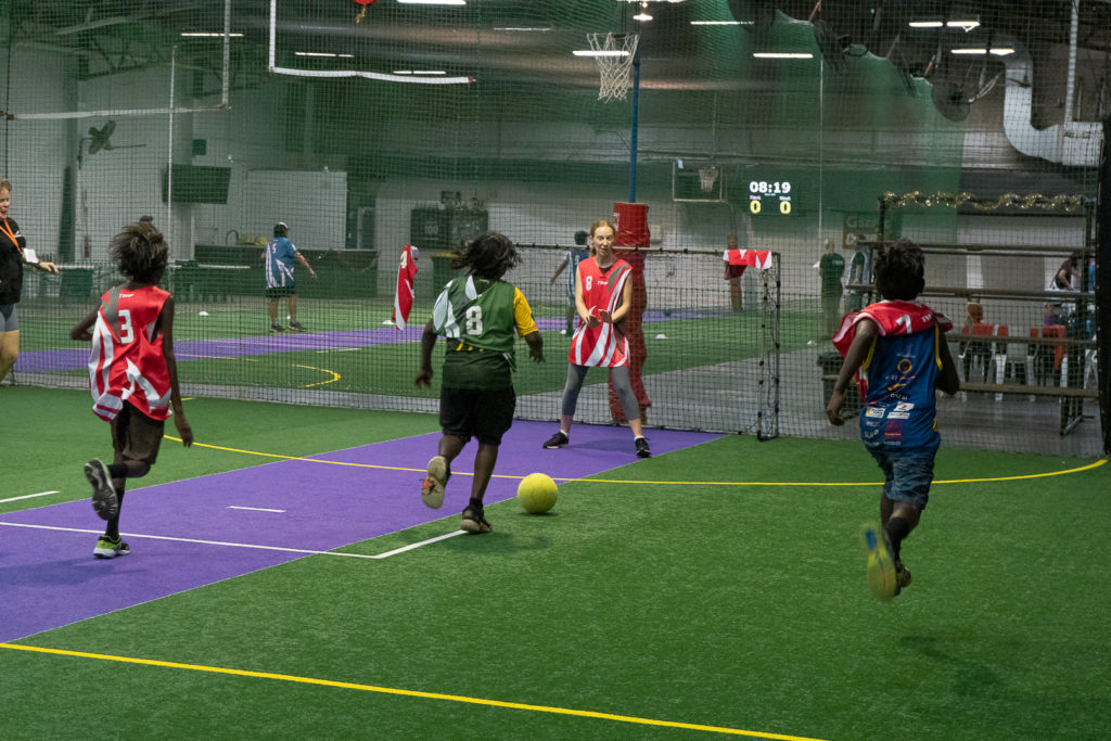 young people playing indoor soccer